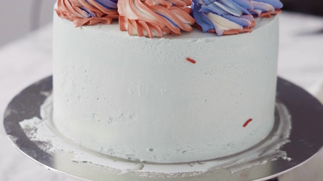 在圆形香草蛋糕的边缘撒上彩色的糖屑。视频下载