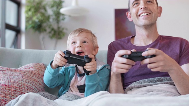 小男孩在和爸爸玩电脑游戏视频下载