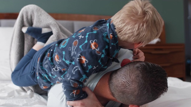 小男孩在床上和爸爸摔跤视频下载