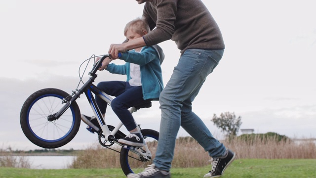 兴奋的小男孩在自行车上做了一个前轮特技视频下载