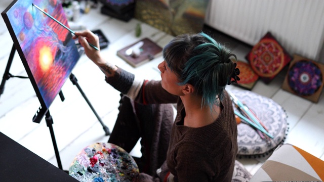 迷人的现代女画家在她舒适的艺术工作室享受她的爱好视频素材