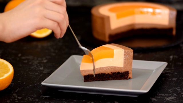 女人吃橘子巧克力慕斯蛋糕的特写。视频下载