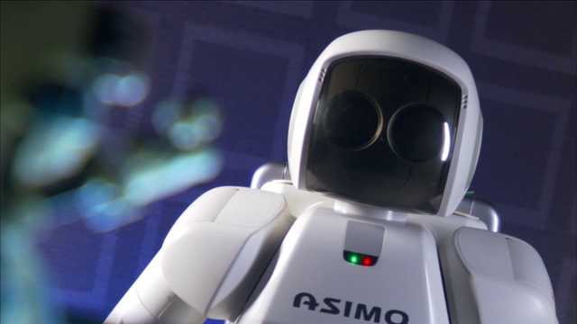 一个ASIMO人形机器人在另一个机器人旁边挥手。视频下载