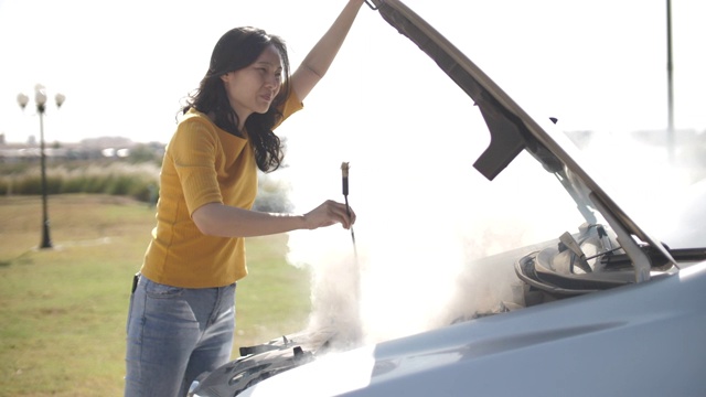 亚洲女人车抛锚在路上打开散热器引擎盖车和看到引擎视频购买