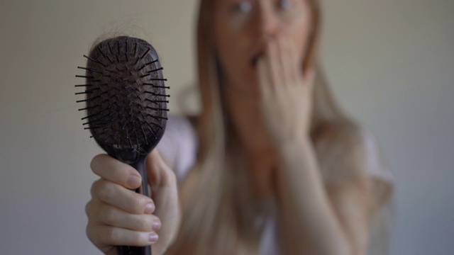 年轻女子遭受脱发之苦。脱发的概念视频素材