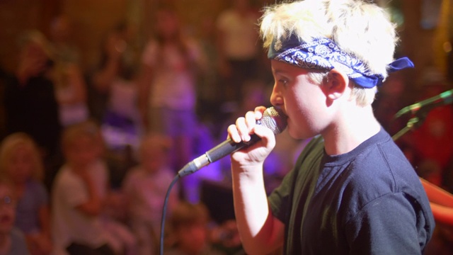 一个音乐家，歌手，摇滚明星，青少年，在一个摇滚乐队的舞台上唱歌。——慢动作视频下载