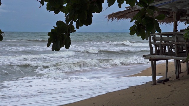 在东南亚季风中的海浪拍打着印度洋海岸的海滩上的乡村木屋视频素材