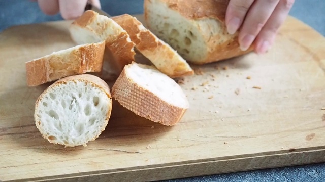在木板上切成片法棍面包。在家做饭视频素材