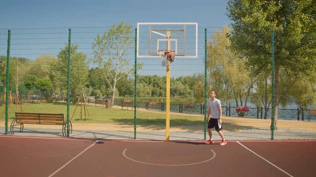 这是一幅特写，年轻漂亮的白人男性篮球运动员在球场上投球，背景是城市建筑视频下载