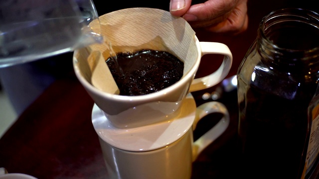 将新煮好的黑咖啡倒入杯中。视频素材