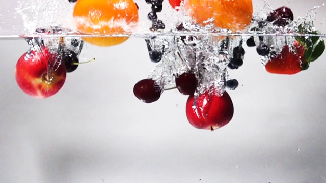 超級慢動作:在白色背景下混合水果滴入淡水中視頻下載