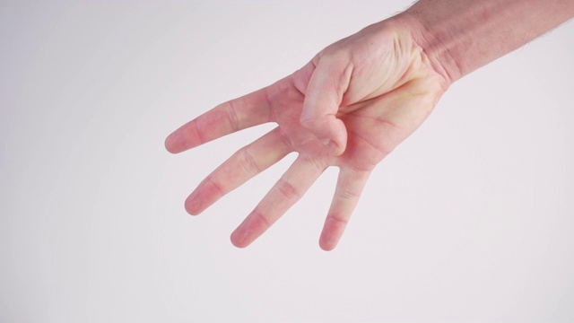 一个年轻人用手指在白色背景上显示从5到0的倒计时。国际手语视频下载