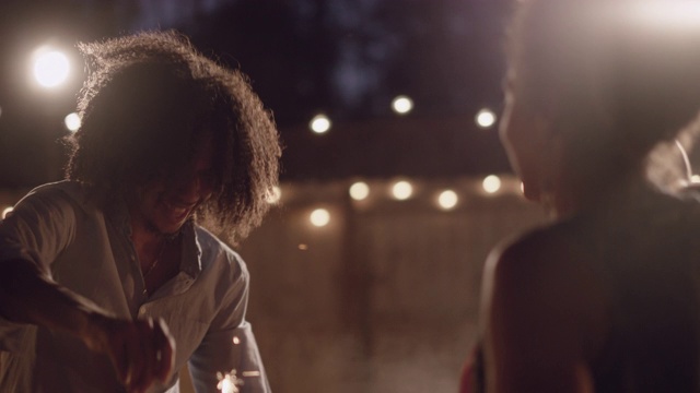 SLO MO，美丽的非裔美国人夫妇拿着烟花跳舞旋转视频素材