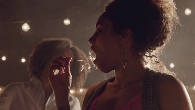 SLO MO，美丽的非裔美国女人假装吃了一个烟花视频素材