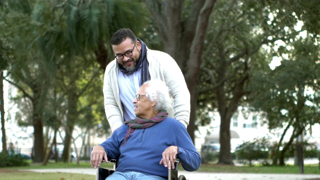 坐轮椅的西班牙裔老人，还有成年的儿子视频下载