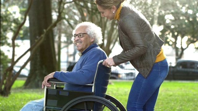 西班牙裔妇女推着轮椅上的父亲视频素材