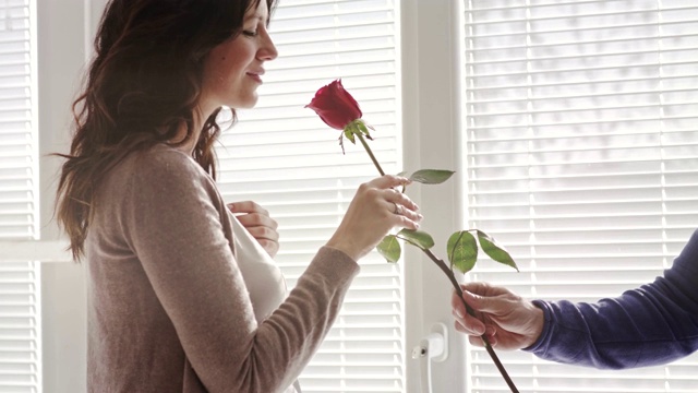 女人闻着爱人的丈夫送给她的情人节玫瑰视频素材