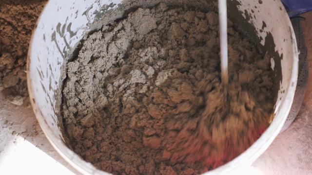 长钻搅拌机搅拌水泥砂和水生成胶浆。缓慢的运动。建筑的概念视频素材