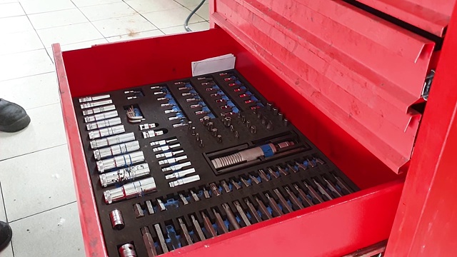 车库里的机械师把工具放在红色的金属盒子里，特写视频素材