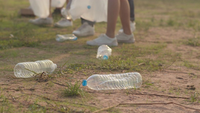 一群年轻的多民族活动人士在海滩上收集塑料垃圾。视频素材