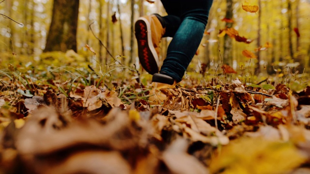 在田園詩般的森林里，女人在秋葉中奔跑視頻素材