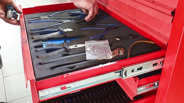 机修工打开一个红色的金属盒子，把工具放在那里视频素材