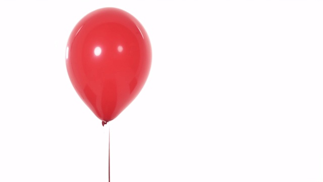 充满氦气的红色气球出现在镜头中。孤立，在白色背景上。副本的空间。情人节礼物概念视频下载