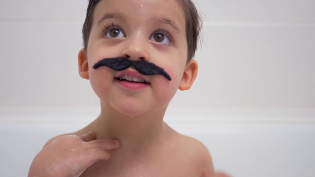 一个长着黑胡子的小男孩坐在浴室里视频下载