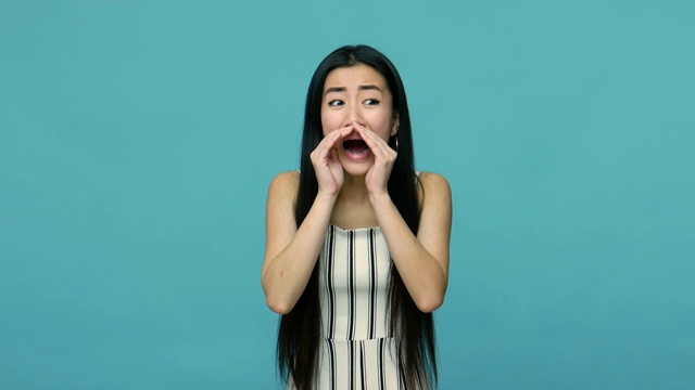 大声宣布!年轻的亚洲妇女抱着大张的嘴和呼喊广告视频购买