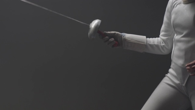 动作手持式的两个击剑决斗在一个灰尘和黑暗的体育馆视频下载