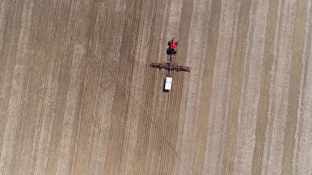 美国伊利诺斯州林登镇附近，拖拉机在春耕和施肥。无人机视频与向前平移和倾斜相机运动。视频下载