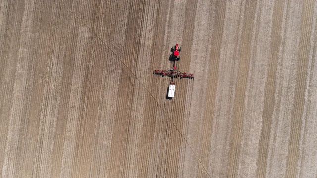 美国伊利诺斯州林登镇附近，拖拉机在春耕和施肥。无人机视频与平移摄像机运动跟踪拖拉机。视频下载