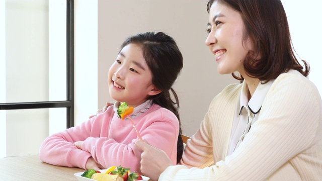 小学女孩微笑和老师与蔬菜在她的手视频素材