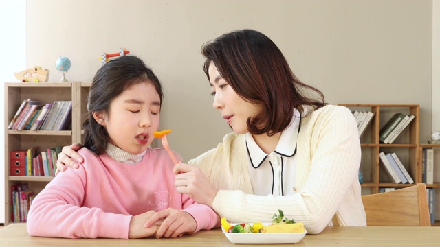 老师鼓励挑食的小学女生吃蔬菜视频素材