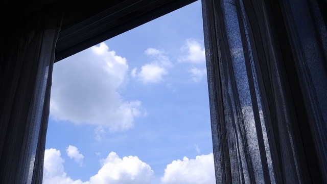 蓝天白云，从挂着窗帘的玻璃窗往外看视频素材