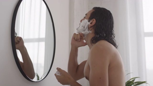 男人在浴室里用剃须泡沫洗脸视频素材