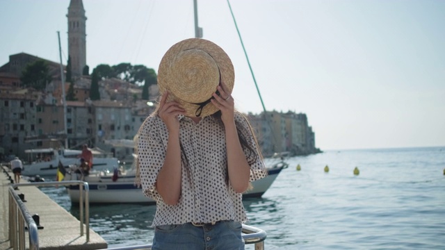 克罗地亚罗温伊镇，一名女游客正在玩夏帽视频素材