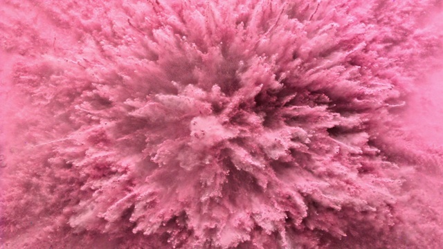 在近距离和超慢的动作中，充满了粉色粉末的表面向相机喷射，产生烟熏质感视频素材
