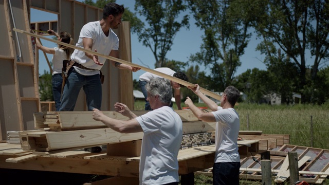 志愿者在一个慈善建筑工地组织一堆胶合板视频素材