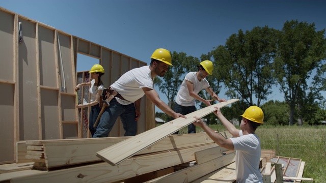 在一个阳光明媚的日子里，一群志愿者在一个慈善建筑工地辛勤工作视频素材