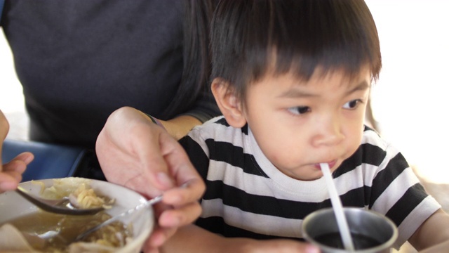 SLO MO，小男孩吃泰国面视频素材