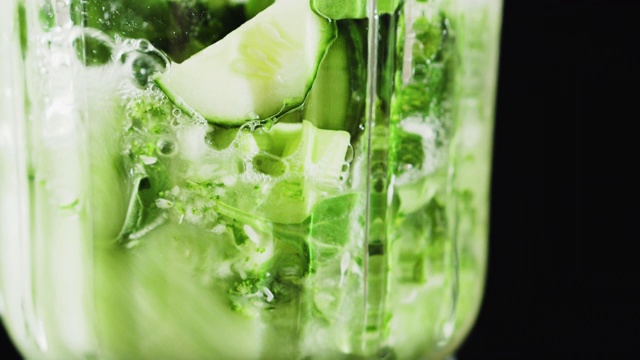 绿色奶昔混合在搅拌机里，特写。健康饮食的概念。视频素材