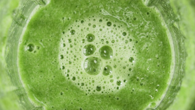 绿色奶昔混合搅拌器，俯视图，慢动作。健康饮食的概念。视频素材