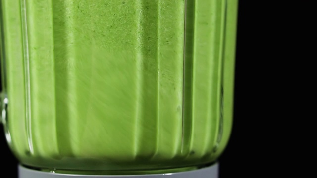 绿色奶昔混合在搅拌机里，特写，慢动作。健康饮食的概念。视频素材