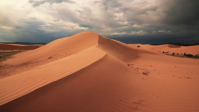 日落时沙漠中的沙丘。强风视频下载