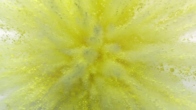 柠檬黄色的粉末在特写和超级慢镜头，白色背景中向相机爆炸视频下载