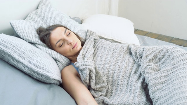 年轻漂亮的女人在卧室里安静地睡觉。放松和健康睡眠的概念视频下载