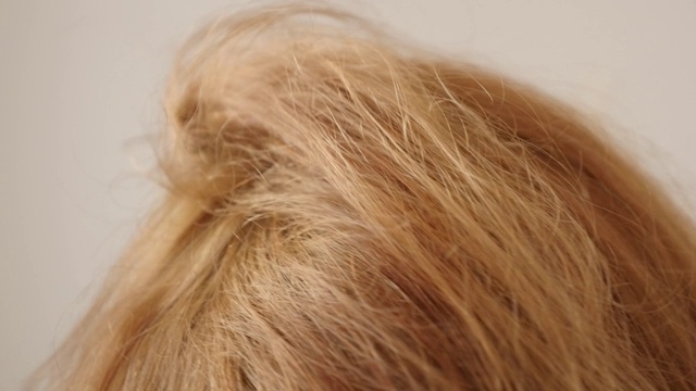 电吹风用在金发女人头发上的慢动作视频素材