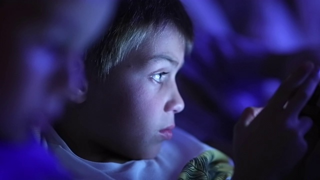 孩子们在平板电脑屏幕前，脸上闪着蓝光视频素材