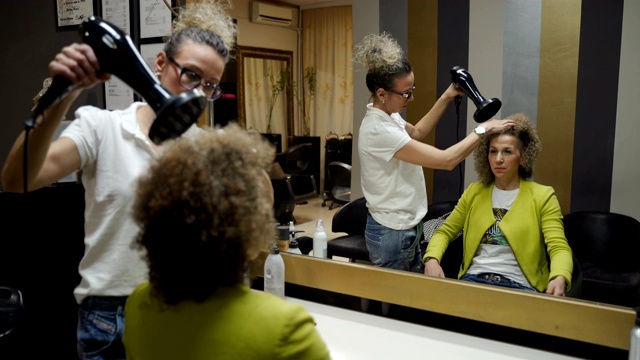 健康的头发。一名女性客户在当地的美容院理发视频下载